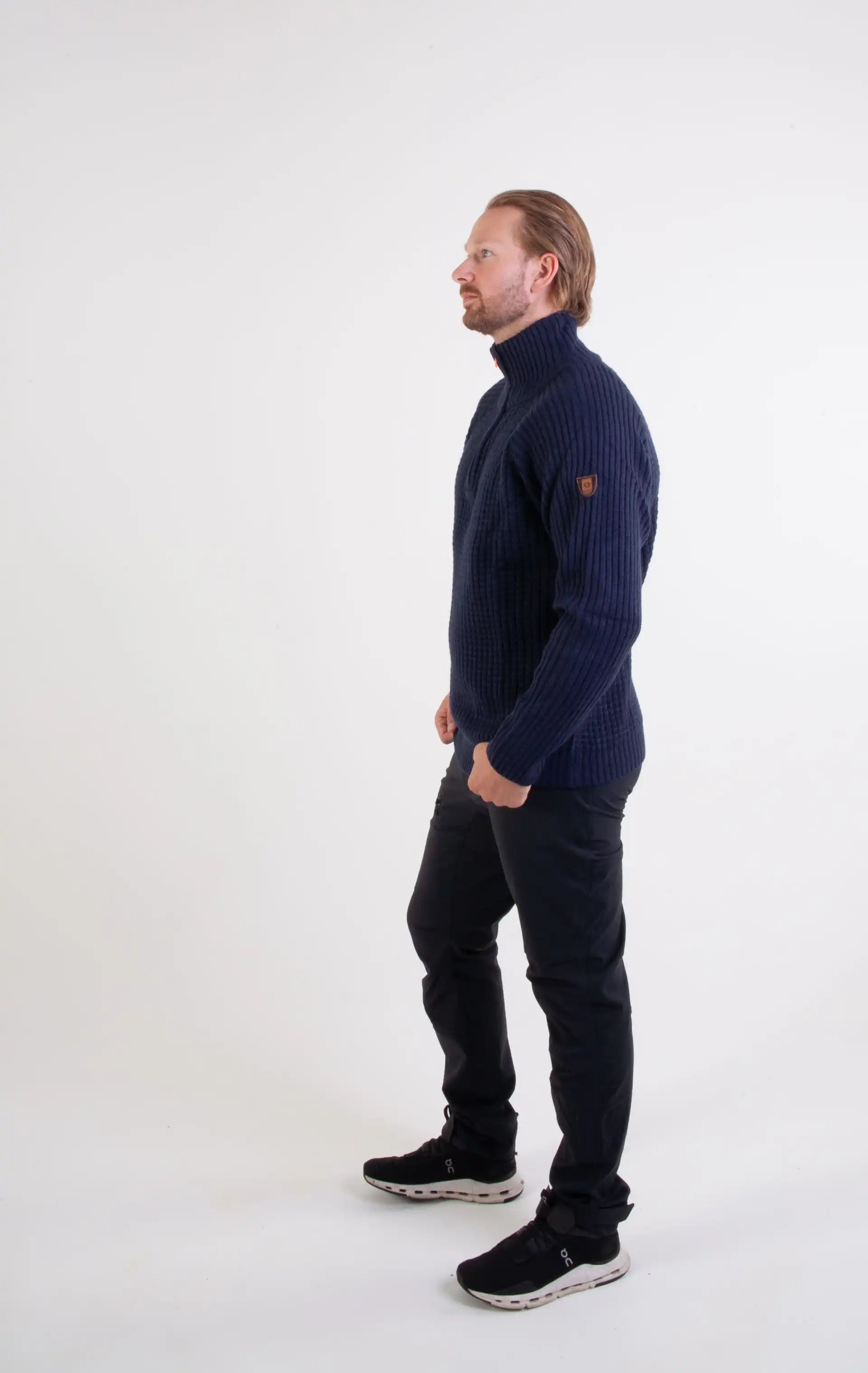 Ullgenser Villmark i blå og orange med høy hals og glidelås, tommelhull for komfort, laget av slitesterk ullblanding, perfekt for friluftsliv og hverdagsbruk.