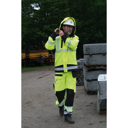 Lyngsøe Rainwear bukse i 4-veis stretch hi-vis gul/sort, designet for komfort og synlighet i krevende arbeidsforhold, med elastisk midje, avtagbare skulderstropper, pustende og vanntett materiale, perfekt for all slags vær.