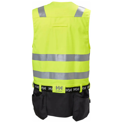 Helly Hansen Alna 2.0 Construction Vest - funksjonell håndverkervest med 2-veis stretchmateriale, forbedret passform, forlengbar front, sømløse refleksbånd for økt sikkerhet, designet for komfort og stil for profesjonelle håndverkere.